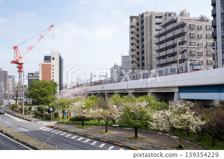 [Keikyu Main Line] Express train passing by a park with cherry blossoms in bloom. 139354229