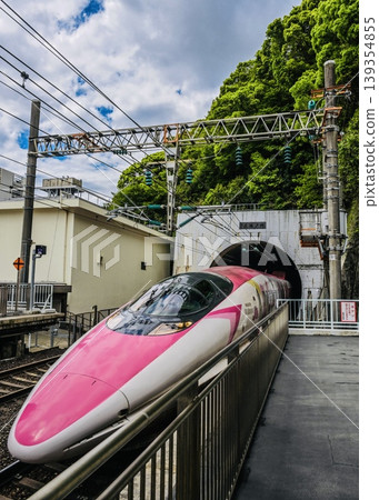 The Hello Kitty Shinkansen, nearing retirement, emerges from a tunnel and arrives (two photos). The Hello Kitty Shinkansen, nearing retirement, emerges from a tunnel and arrives (two photos). 139354855