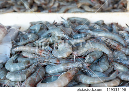 Fresh raw shrimp piled at seafood market showing natural texture and freshness ideal for food industry aquaculture and culinary themes Fresh raw shrimp piled at seafood market showing natural texture and freshness ideal for food industry aquaculture and culinary themes 139355496