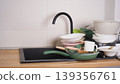Dirty dishes accumulating in a messy kitchen sink, waiting for washing 139356761