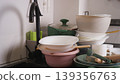 Stacked dirty plates, bowls, and pots needing washing in a messy kitchen sink 139356763