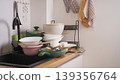 Dirty pots, pans, and plates filling a kitchen sink and counter, representing housework 139356764