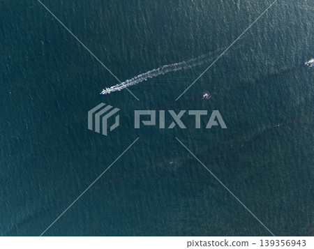Boat moves across water in sunny weather at a coastal location Boat moves across water in sunny weather at a coastal location 139356943