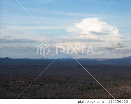 Vast landscape with mountains and clouds near a forested area Vast landscape with mountains and clouds near a forested area 139356960