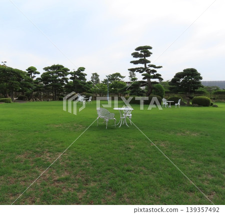 White chairs and tables in the garden of Jinpukaku in summer White chairs and tables in the garden of Jinpukaku in summer 139357492