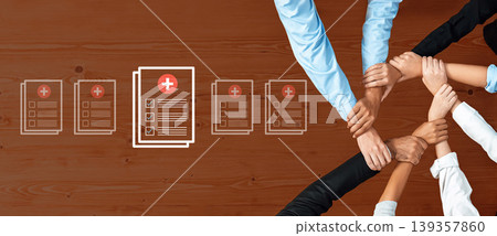 Diverse Hands Joining Together Over Health Documents on Wooden Table Symbolizing Collaboration and Care in Medical or Community Settings Ledger Diverse Hands Joining Together Over Health Documents on Wooden Table Symbolizing Collaboration and Care in Medical or Community Settings Ledger 139357860