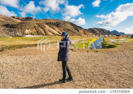 Female traveler among volcanic mountain near campsite at Landmannalaugar, Icelandic Highlands 139358008