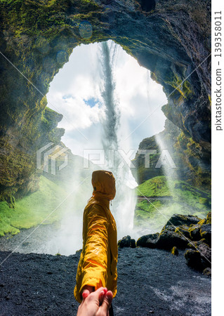Traveler holding hand inside Icelandic Kvernufoss waterfall during summer at Iceland Traveler holding hand inside Icelandic Kvernufoss waterfall during summer at Iceland 139358011