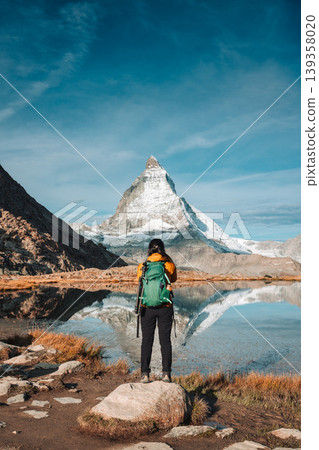 Matterhorn with female tourist standing in Riffelsee Lake, Switzerland Matterhorn with female tourist standing in Riffelsee Lake, Switzerland 139358020