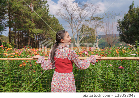 Asian woman enjoying in Straw flower or Everlasting flower blooming on holiday at Phu Hin Rong Kla Asian woman enjoying in Straw flower or Everlasting flower blooming on holiday at Phu Hin Rong Kla 139358042