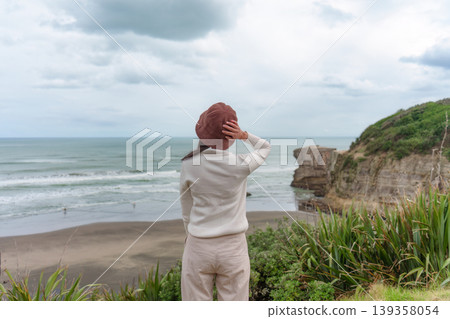 Asian woman enjoying on coastline near Muriwai Gannet Colony in New Zealand 139358054