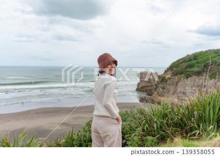 Asian woman enjoying on coastline near Muriwai Gannet Colony in New Zealand Asian woman enjoying on coastline near Muriwai Gannet Colony in New Zealand 139358055