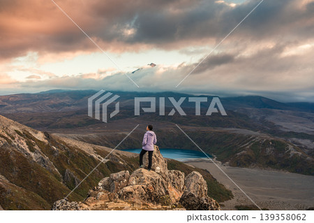 Asian hiker woman standing on Tama Lakes viewpoint with Mount Ruapehu hiding in the cloud at Tongariro national park, New Zealand 139358062
