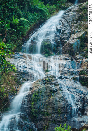 Waterfall cascading over rocky terrain in tropical forest at Vietnam Waterfall cascading over rocky terrain in tropical forest at Vietnam 139358158