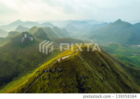 Scenery of Ba Guang grass hill, Mountain range with fog and villager bringing horse to graze on the mountain in the morning Scenery of Ba Guang grass hill, Mountain range with fog and villager bringing horse to graze on the mountain in the morning 139358164