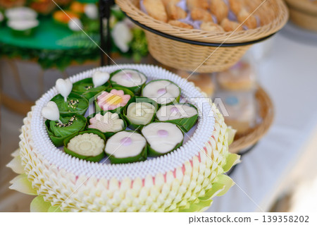 Beautiful and appetizing traditional Thai desserts including crispy curry puffs, sweet treats and jelly desserts on dessert table Beautiful and appetizing traditional Thai desserts including crispy curry puffs, sweet treats and jelly desserts on dessert table 139358202