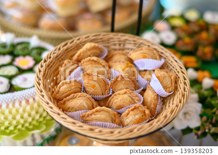 Beautiful and appetizing traditional Thai desserts including crispy curry puffs, sweet treats and jelly desserts on dessert table Beautiful and appetizing traditional Thai desserts including crispy curry puffs, sweet treats and jelly desserts on dessert table 139358203