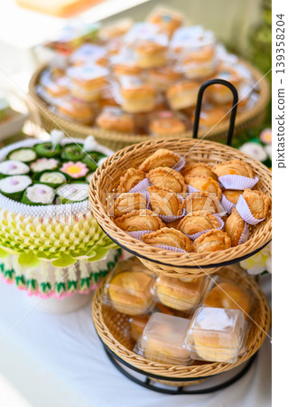 Beautiful and appetizing traditional Thai desserts including crispy curry puffs, sweet treats and jelly desserts on dessert table Beautiful and appetizing traditional Thai desserts including crispy curry puffs, sweet treats and jelly desserts on dessert table 139358204