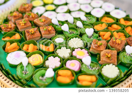 Beautiful and appetizing traditional Thai desserts including crispy curry puffs, sweet treats and jelly desserts on dessert table Beautiful and appetizing traditional Thai desserts including crispy curry puffs, sweet treats and jelly desserts on dessert table 139358205