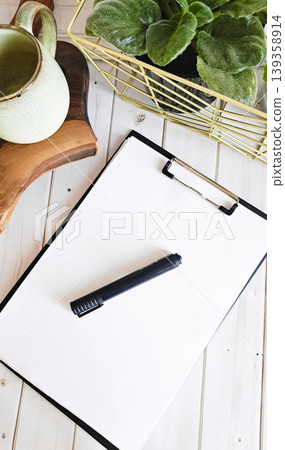 Clipboard with blank paper, mug and plant on desk Clipboard with blank paper, mug and plant on desk 139358914