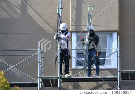Dismantling site of temporary scaffolding during large-scale apartment building renovation. Dismantling site of temporary scaffolding during large-scale apartment building renovation. 139359294
