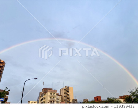 A large rainbow arches over the cityscape; a scene after the rain. A large rainbow arches over the cityscape; a scene after the rain. 139359432