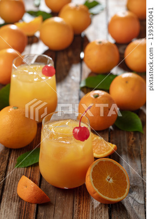 Orange juice with ice garnished with red cherry. Orange juice with ice garnished with red cherry. 139360041