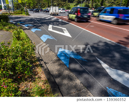 A bicycle navigation line installed along a left-turn-only lane and a city road traffic scene. A bicycle navigation line installed along a left-turn-only lane and a city road traffic scene. 139360352