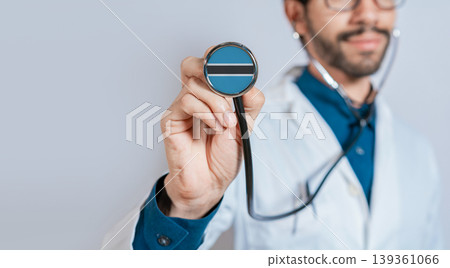 Doctor holding stethoscope with Botswana flag. Botswana health and care concept, Botswana flag on stethoscope Doctor holding stethoscope with Botswana flag. Botswana health and care concept, Botswana flag on stethoscope 139361066