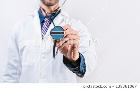 Botswana healthcare system, doctor holding stethoscope. Botswana health and medical insurance concept Botswana healthcare system, doctor holding stethoscope. Botswana health and medical insurance concept 139361067