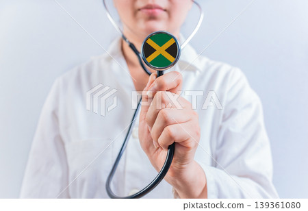 Female doctor holding stethoscope with Jamaica flag. National health system of Jamaica Female doctor holding stethoscope with Jamaica flag. National health system of Jamaica 139361080