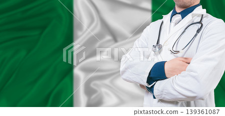 Nigeria healthcare concept. Male doctor on Nigeria flag. Doctor with crossed arms on Nigeria flag 139361087