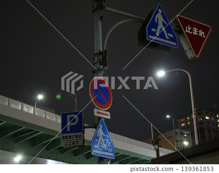 Streets illuminated by street signs and streetlights at night Streets illuminated by street signs and streetlights at night 139361853