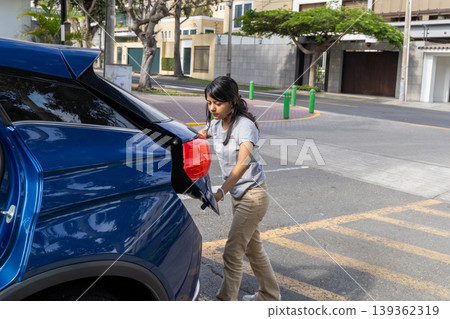 A teenager is pulling a blue car out of a parking spot A teenager is pulling a blue car out of a parking spot 139362319