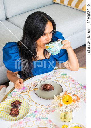 Young brunette woman enjoys eating sweets Young brunette woman enjoys eating sweets 139362340