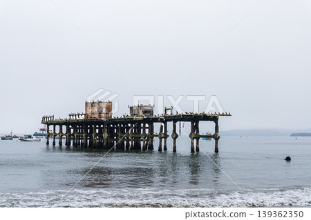 A Chancay pier with a few boats docked in the water 139362350