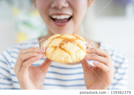 A young woman eating melon bread A young woman eating melon bread 139362379