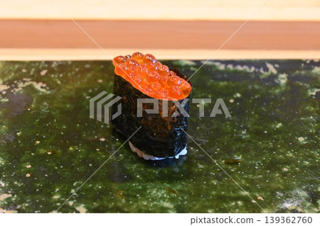 鮮亮的鮭魚籽軍艦卷,壽司上的配料如同寶石般閃耀。 鮮亮的鮭魚籽軍艦卷,壽司上的配料如同寶石般閃耀。 139362760