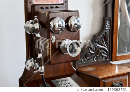 A charming antique wall-mounted telephone, perfect for retro interior decor. A charming antique wall-mounted telephone, perfect for retro interior decor. 139362761