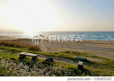 在京都府京丹後市阿野町濱爪夕日浦海灘的日落步道上,坐在沙灘上的長椅上欣賞日落。 在京都府京丹後市阿野町濱爪夕日浦海灘的日落步道上,坐在沙灘上的長椅上欣賞日落。 139363320