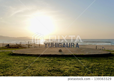 從京都府京都府京丹後市阿彌町濱込日落山夕陽浦海灘的夕陽浦紀念碑後方欣賞日落。 從京都府京都府京丹後市阿彌町濱込日落山夕陽浦海灘的夕陽浦紀念碑後方欣賞日落。 139363329
