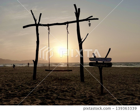 在京都府京丹後市阿野町濱爪夕日浦海灘,坐在沙灘鞦韆上欣賞日落美景。 在京都府京丹後市阿野町濱爪夕日浦海灘,坐在沙灘鞦韆上欣賞日落美景。 139363339