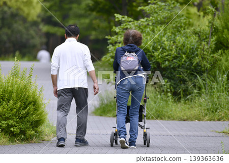 在日本橫濱市,一位老婦人正使用四輪助行器行走在城市景觀中…此時正值綠意盎然的季節…= 橫濱市 在日本橫濱市,一位老婦人正使用四輪助行器行走在城市景觀中…此時正值綠意盎然的季節…= 橫濱市 139363636