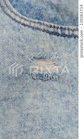 Close-up of stonewashed denim jeans with hole Close-up of stonewashed denim jeans with hole 139363714