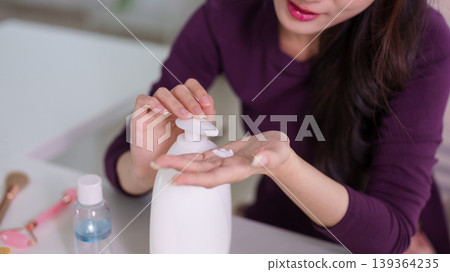 Asian women applying hand cream lotion skincare routine beauty care healthy skin wellness self care lifestyle relaxing at home modern interior hygiene personal 139364235