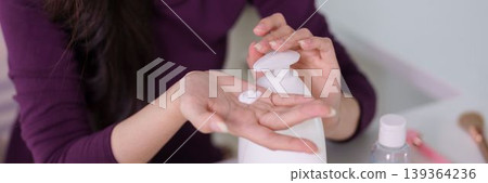Asian women hands applying white moisturizer cream lotion from bottle skincare beauty routine self care treatment wellness hygiene cosmetic product hand care 139364236