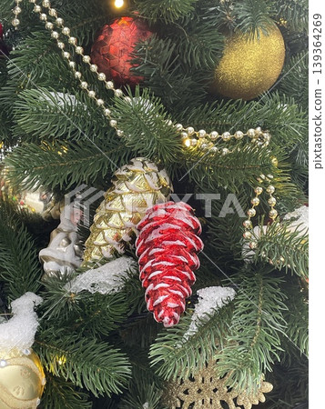 Christmas tree decorated with red pinecone, gold ornaments, beads, and snow creates festive scene Christmas tree decorated with red pinecone, gold ornaments, beads, and snow creates festive scene 139364269