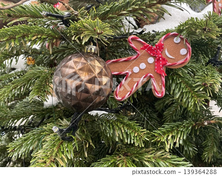 Christmas tree with brown ornament and gingerbread man decoration amidst green branches Christmas tree with brown ornament and gingerbread man decoration amidst green branches 139364288