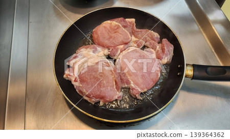 Fresh Pork Loin Chops Searing in a Hot Frying Pan on Stove Top 139364362