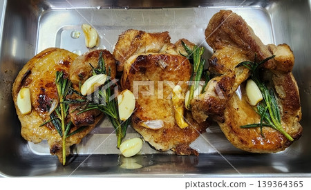 Pan-Seared Pork Chops with Garlic and Fresh Rosemary Sprigs in a Stainless Steel Tray Pan-Seared Pork Chops with Garlic and Fresh Rosemary Sprigs in a Stainless Steel Tray 139364365